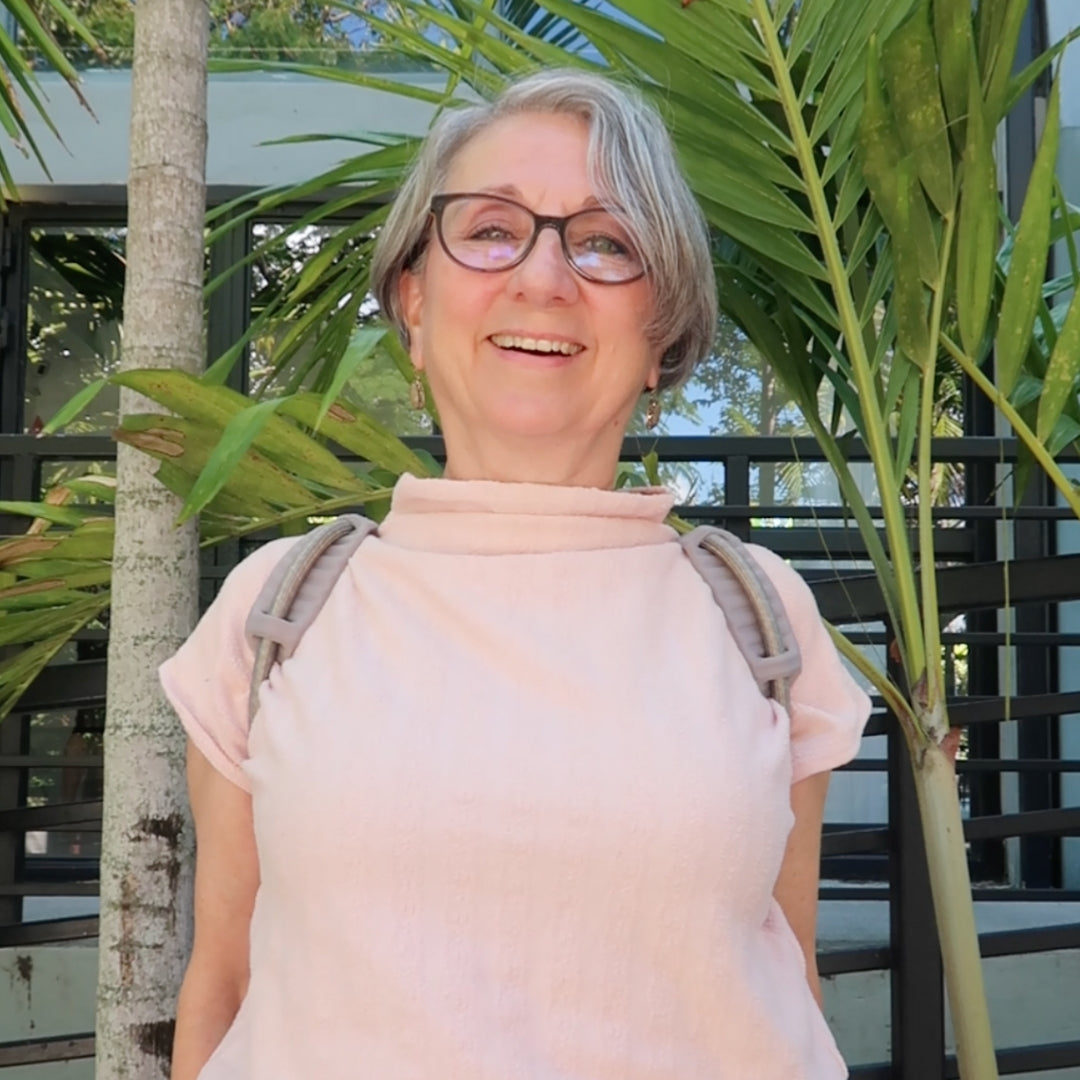 A smiling office worker happily showing off The Back Transformer posture corrector 